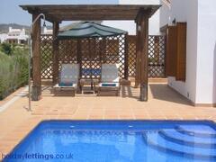 Property Photo: Stunning Pool and Sunlounger Area